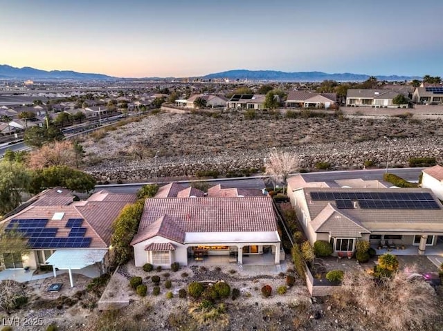 aerial view at dusk featuring a residential view and a mountain view