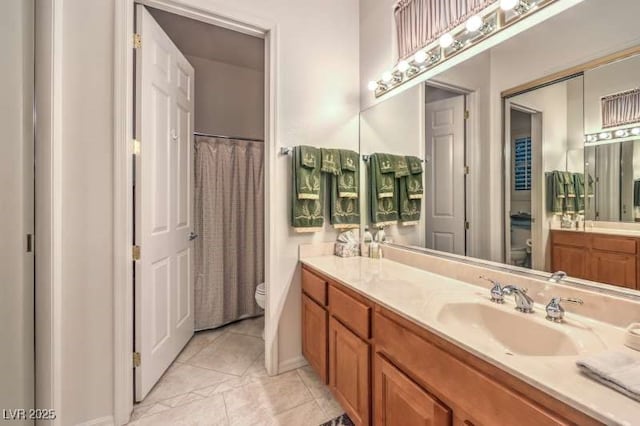 bathroom with tile patterned flooring, vanity, and toilet