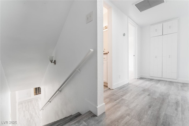 interior space with baseboards, visible vents, and wood finished floors