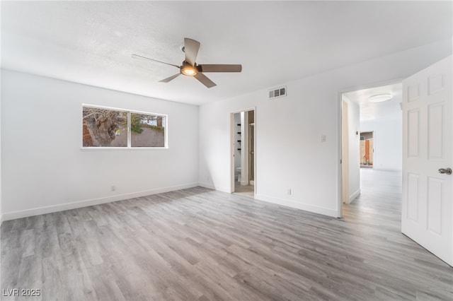 spare room featuring light wood-style floors, baseboards, and visible vents