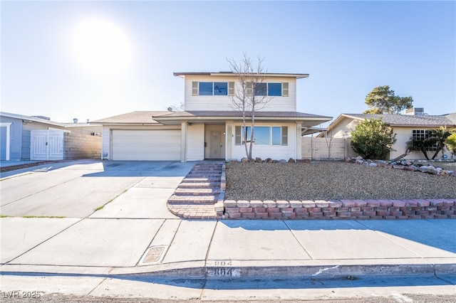 traditional home featuring concrete driveway, an attached garage, and fence