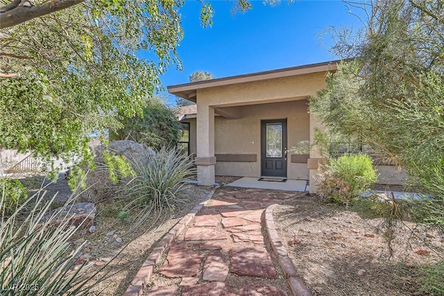 entrance to property featuring stucco siding