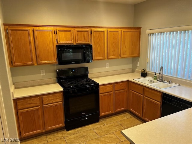 kitchen with light tile patterned floors, a sink, light countertops, brown cabinets, and black appliances