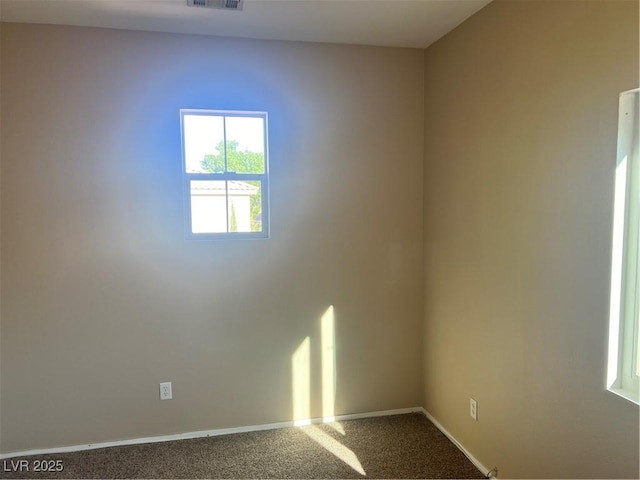 empty room with carpet floors, visible vents, and baseboards