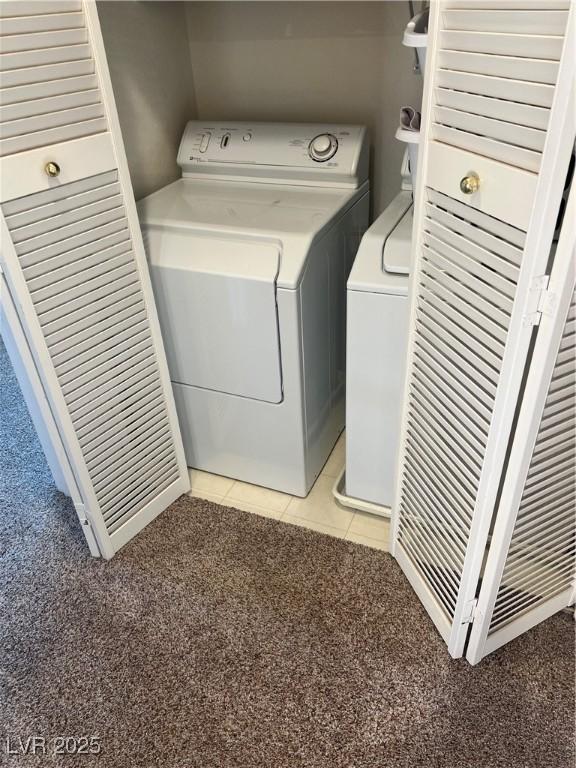 laundry room featuring laundry area, light colored carpet, independent washer and dryer, and light tile patterned floors