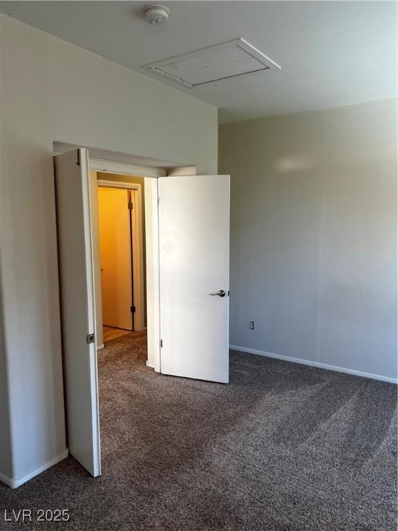 spare room featuring dark colored carpet