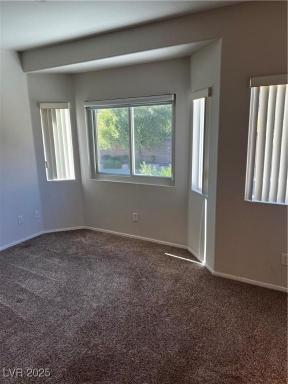 carpeted spare room featuring baseboards