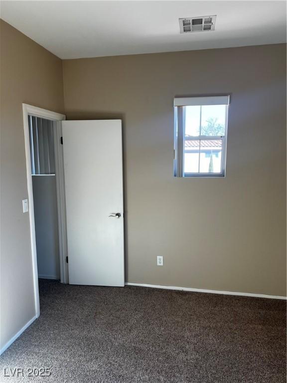 unfurnished bedroom featuring carpet floors, visible vents, and baseboards