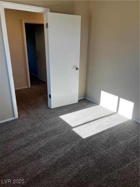 unfurnished room with dark carpet