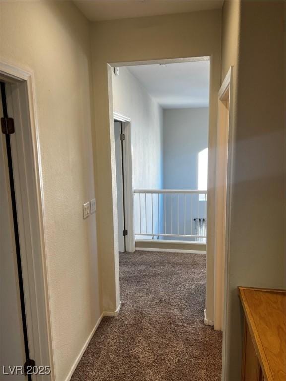 hallway featuring carpet floors and baseboards