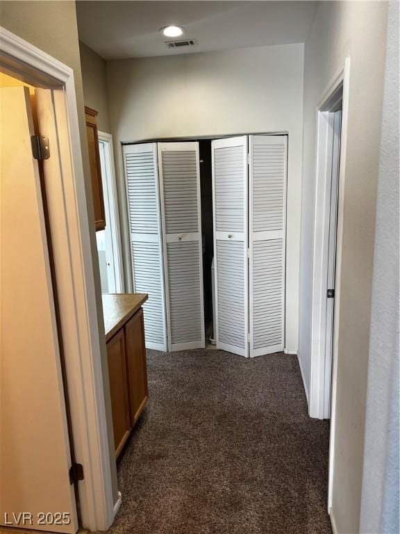 corridor featuring recessed lighting, visible vents, and dark carpet