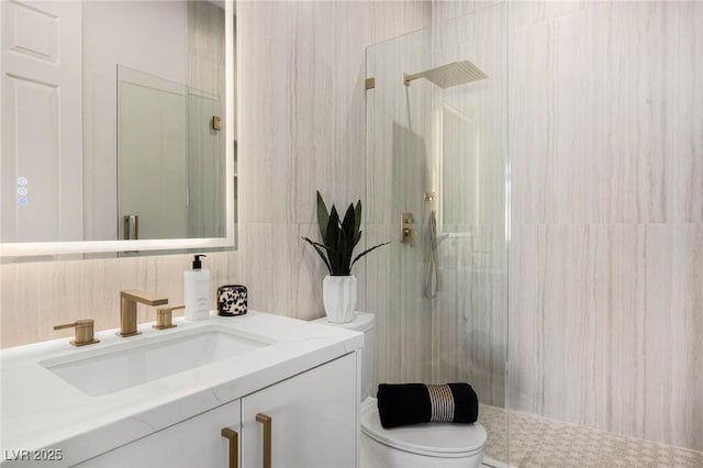 full bathroom featuring tile walls, a stall shower, toilet, and vanity