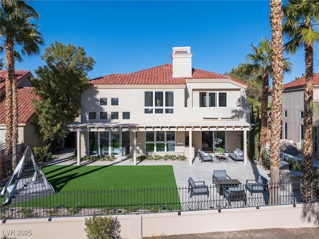 back of house featuring a tile roof, an outdoor living space, a yard, fence private yard, and a patio area