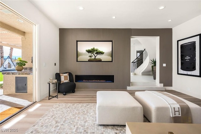 living area featuring recessed lighting, baseboards, wood finished floors, and a fireplace