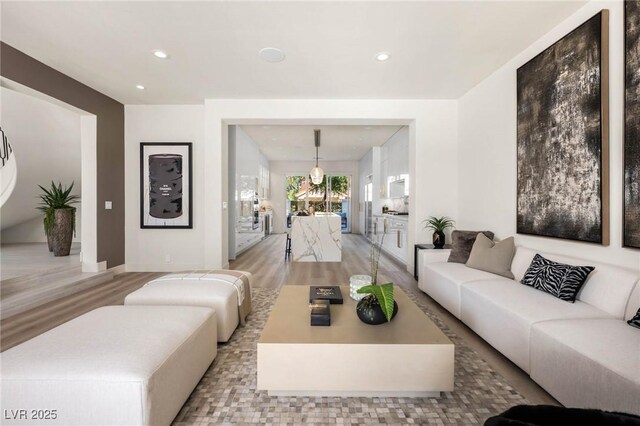 living area with light wood-style flooring, recessed lighting, and baseboards