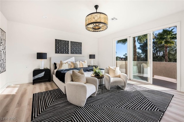 bedroom featuring access to exterior, wood finished floors, and visible vents