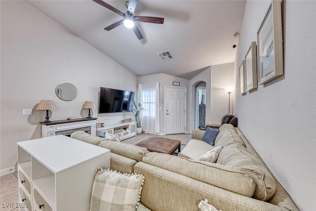 living area featuring visible vents, arched walkways, a ceiling fan, lofted ceiling, and light tile patterned flooring