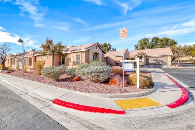 view of front of house with driveway, a residential view, and stucco siding