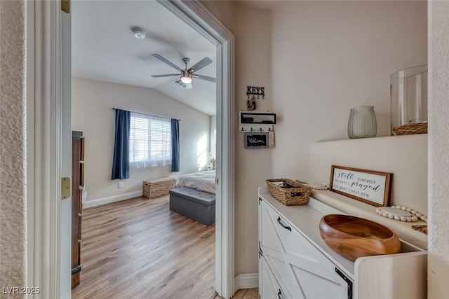 bathroom featuring vaulted ceiling, ceiling fan, wood finished floors, and baseboards