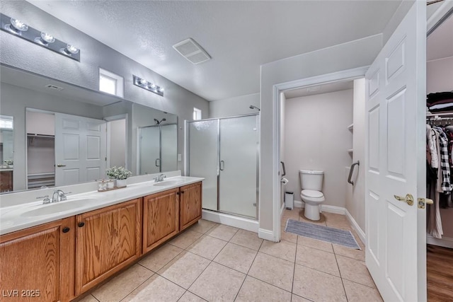 full bath with visible vents, toilet, a sink, a shower stall, and tile patterned floors