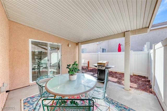 view of patio / terrace featuring outdoor dining space, fence, and a grill