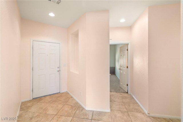 hall featuring light tile patterned floors, visible vents, baseboards, and recessed lighting