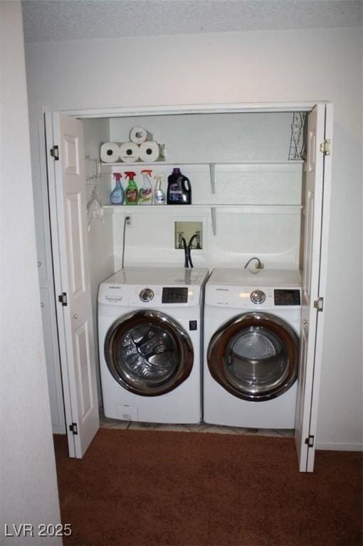 clothes washing area with dark colored carpet, laundry area, a textured ceiling, and washing machine and clothes dryer