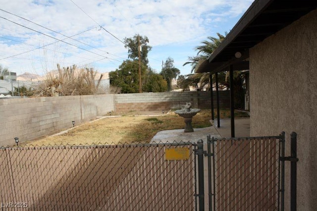 view of yard featuring a fenced backyard and a gate