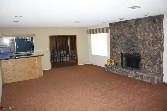 unfurnished living room featuring visible vents, a fireplace, and carpet flooring