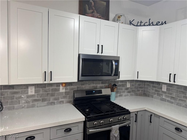 kitchen with decorative backsplash, light countertops, gray cabinets, and stainless steel appliances