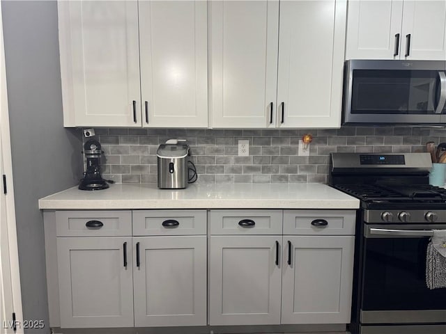 kitchen with light countertops, white cabinets, backsplash, and stainless steel appliances