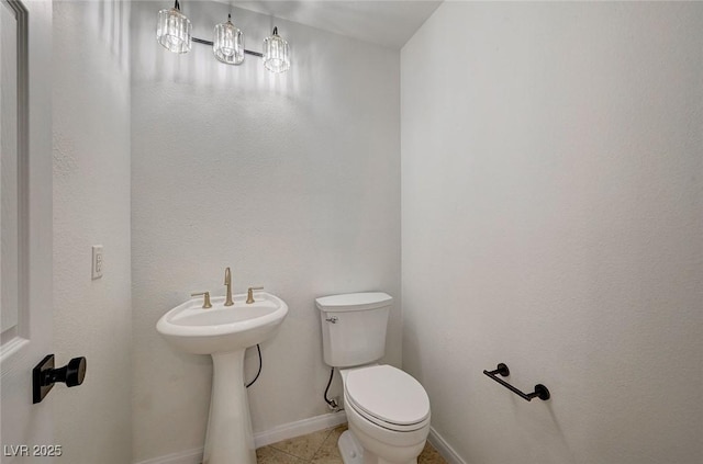 half bathroom featuring tile patterned flooring, toilet, and baseboards