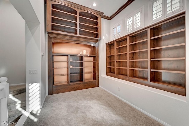 spare room featuring carpet floors, baseboards, and crown molding