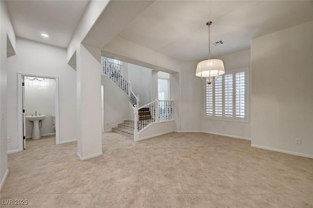 interior space with visible vents, a sink, stairway, and baseboards