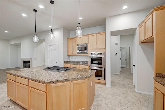 kitchen with light brown cabinetry, appliances with stainless steel finishes, and decorative light fixtures