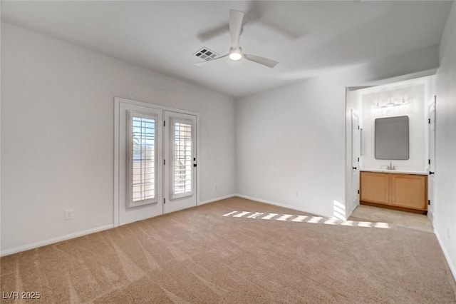 empty room featuring light carpet, baseboards, visible vents, ceiling fan, and a sink