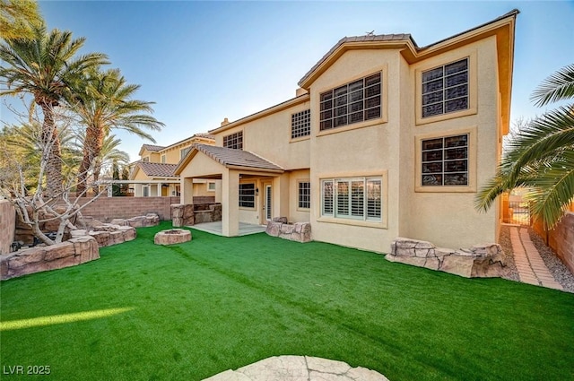 rear view of house with a patio, a fenced backyard, a tile roof, a yard, and stucco siding