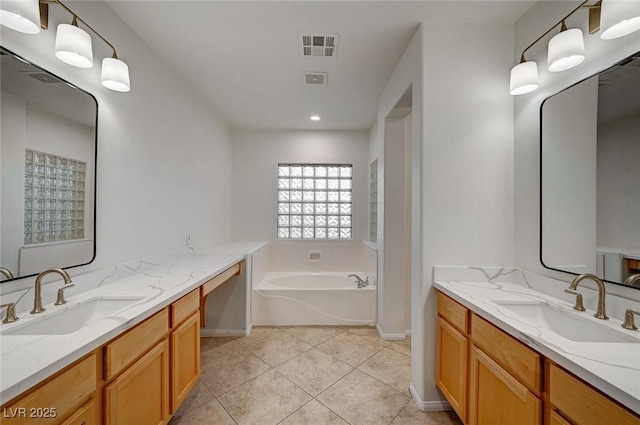 bathroom with two vanities, tile patterned flooring, a garden tub, and a sink