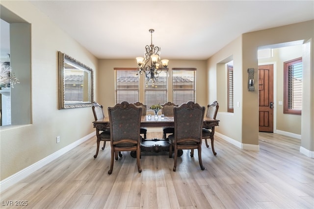 dining space featuring baseboards, plenty of natural light, and light wood finished floors