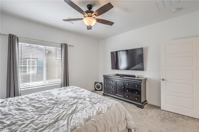 bedroom with a ceiling fan, light colored carpet, and baseboards