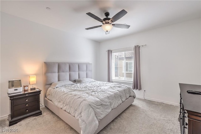 bedroom featuring a ceiling fan, light colored carpet, and baseboards