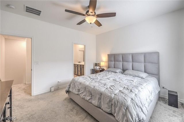 carpeted bedroom with visible vents, connected bathroom, ceiling fan, a sink, and baseboards