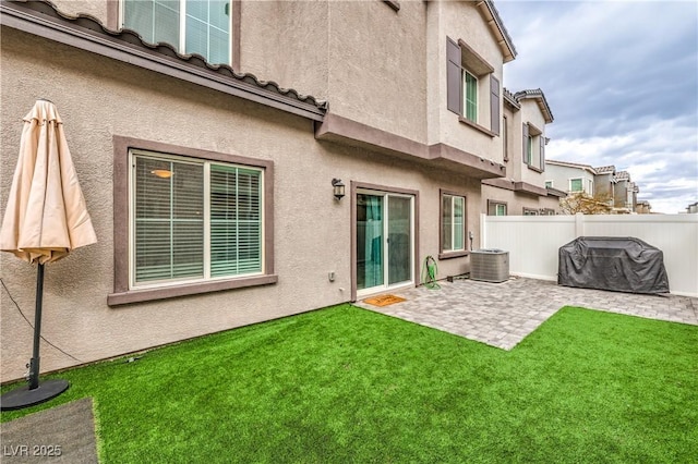 rear view of property with a patio, fence, cooling unit, a yard, and stucco siding