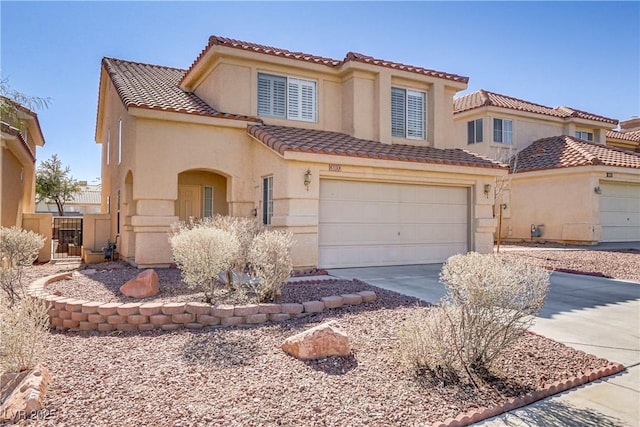 mediterranean / spanish-style home featuring a garage, concrete driveway, a tile roof, and stucco siding