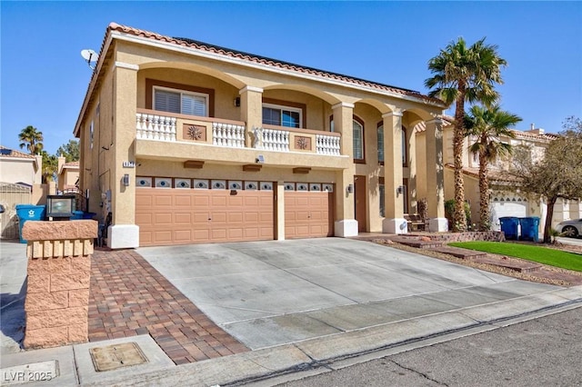 view of front of house featuring stucco siding, concrete driveway, a balcony, a garage, and a tiled roof