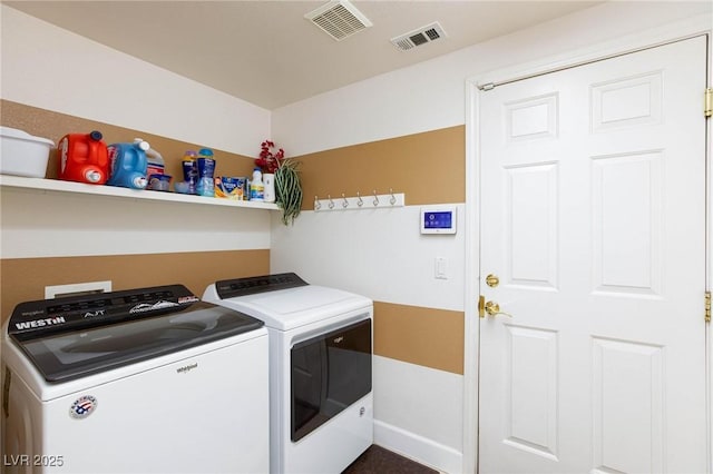 laundry area with laundry area, washing machine and dryer, and visible vents