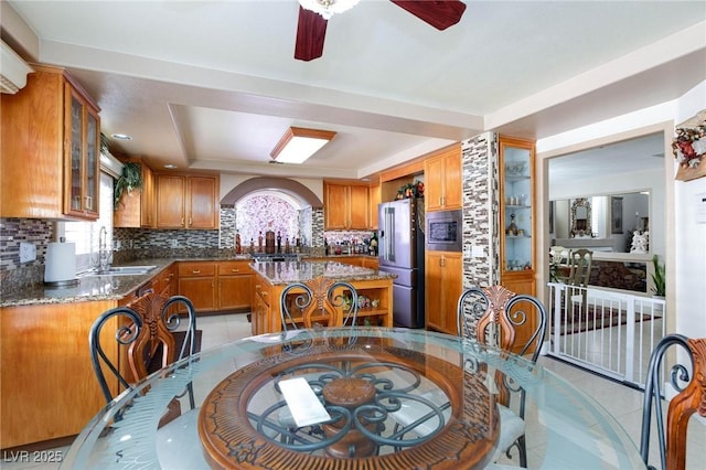 kitchen featuring brown cabinetry, stainless steel appliances, and a sink