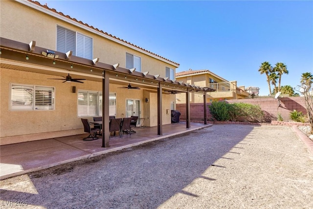 rear view of property featuring a patio, a fenced backyard, a ceiling fan, and stucco siding