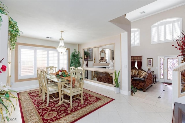 dining space featuring baseboards, visible vents, a notable chandelier, and light tile patterned flooring