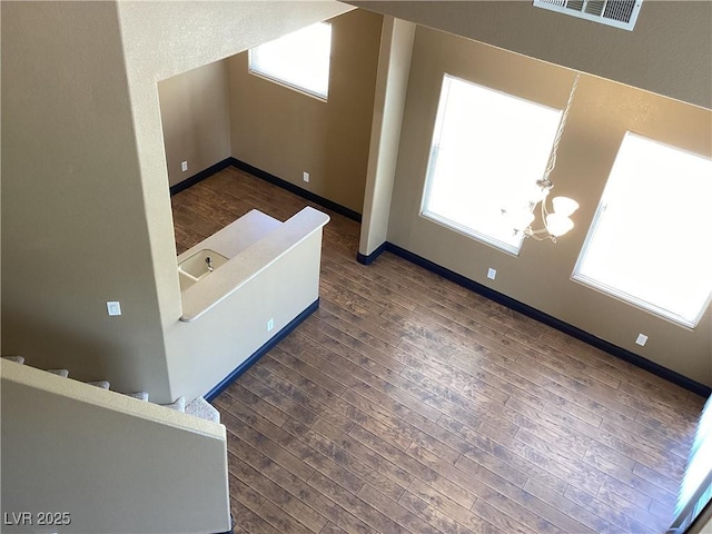 bonus room with baseboards, visible vents, stairway, dark wood-style flooring, and a chandelier